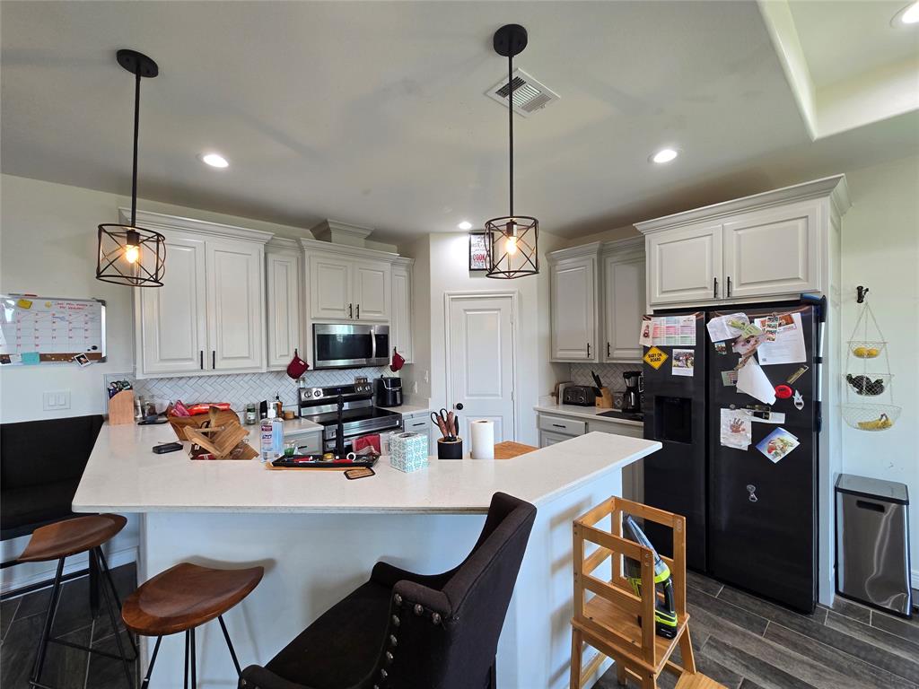 109 Baker Street Mount Vernon, TX 75457 - Photo 9 of 23 a kitchen with a dining table chairs and refrigerator