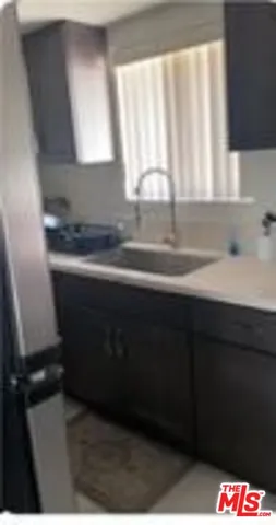 a kitchen with a sink a window and cabinets