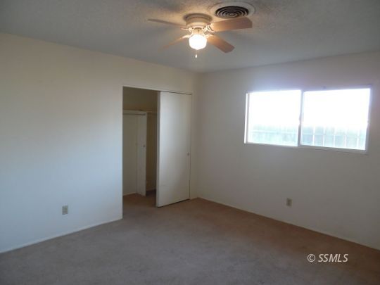 1612 South Yorktown Street Ridgecrest, CA 93555 - Photo 16 of 26 an empty room with a window and a fan