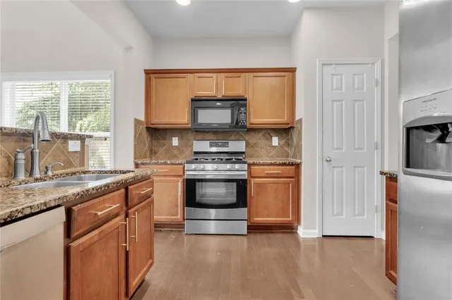 a kitchen with granite countertop a stove and a refrigerator