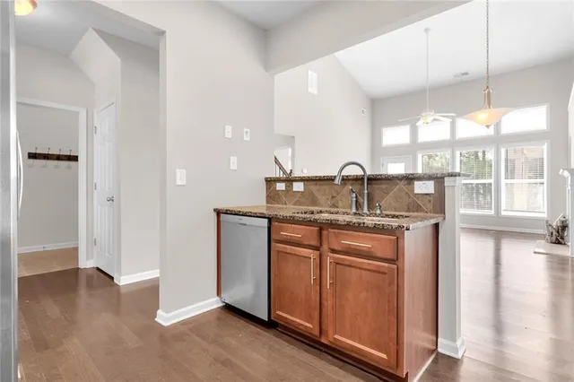 a kitchen with granite countertop a sink and cabinets