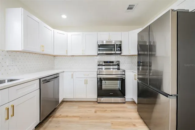 a kitchen with stainless steel appliances a refrigerator stove and microwave