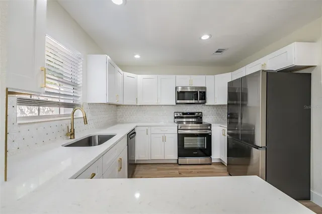 a kitchen with stainless steel appliances granite countertop a refrigerator sink and stove