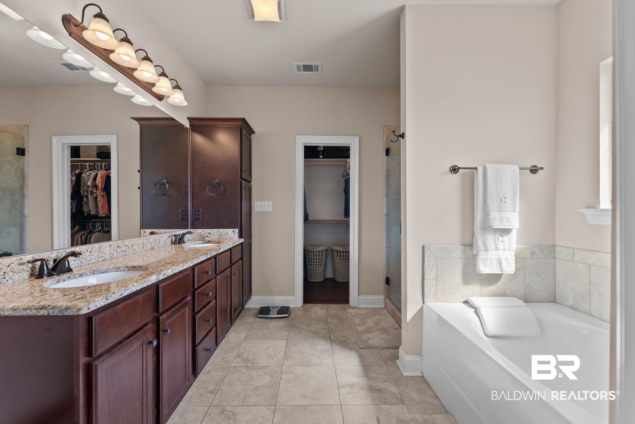 7015 Rocky Rd Loop Gulf Shores, AL 36542 - Photo 31 of 41 Bathroom with a walk in closet, a stall shower, double vanity, and a garden tub