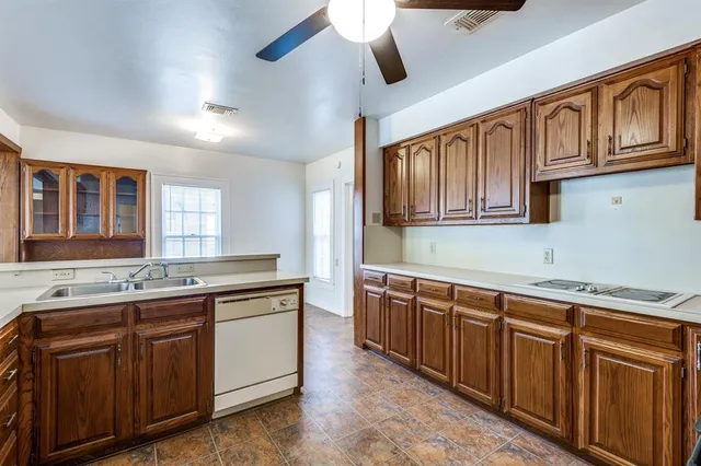 a kitchen with stainless steel appliances granite countertop a sink and dishwasher a stove with wooden cabinets