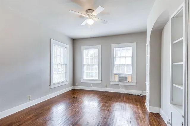 an empty room with wooden floor and window