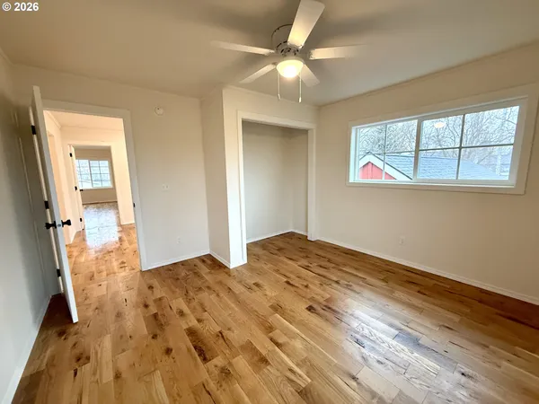 a view of empty room with wooden floor