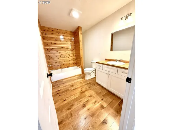 a bathroom with a bathtub sink and mirror