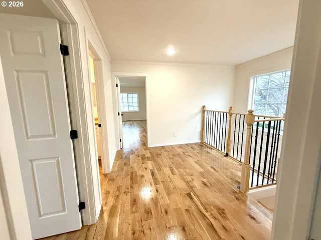 a view of a hallway with wooden floor and entryway