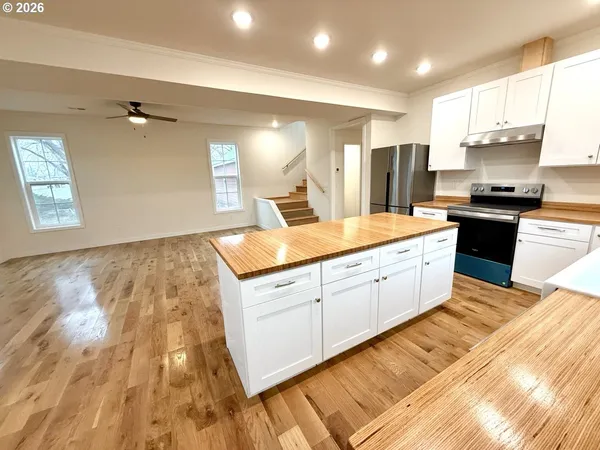 a large kitchen with kitchen island a sink stainless steel appliances and cabinets
