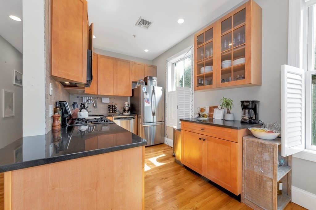 10 East Springfield Street, Unit 3 Boston, MA 02118 - Photo 11 of 26 a kitchen with stainless steel appliances granite countertop a refrigerator a stove and a sink with wooden floor