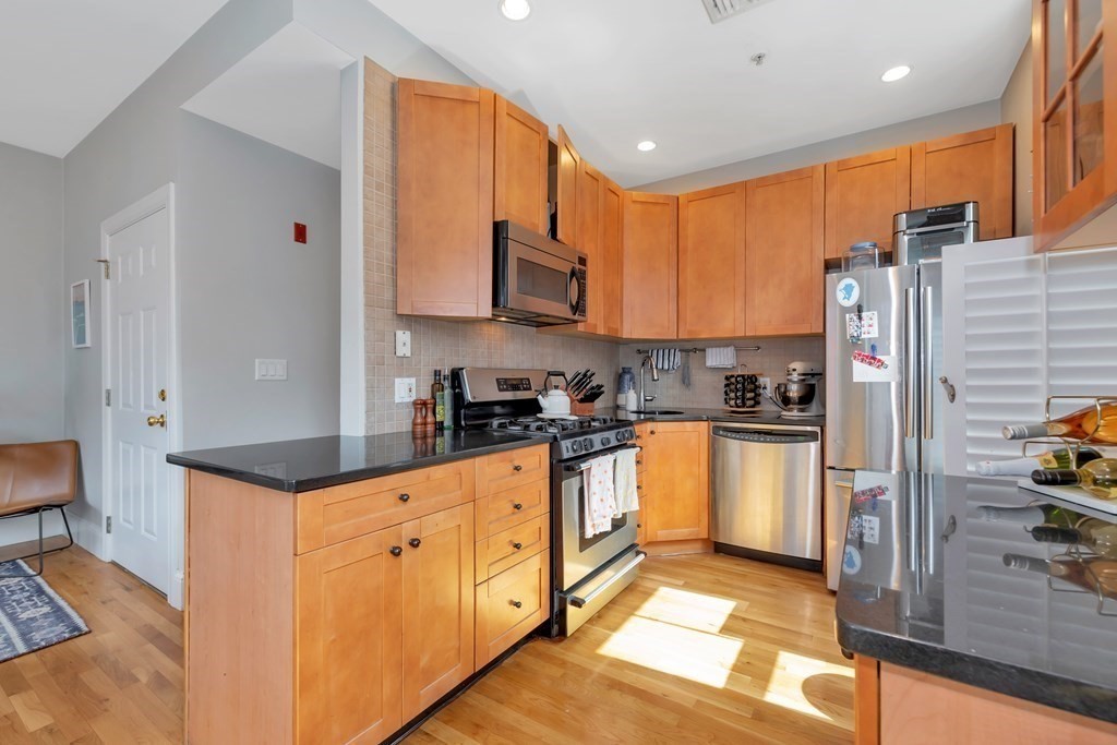 10 East Springfield Street, Unit 3 Boston, MA 02118 - Photo 12 of 26 a kitchen with stainless steel appliances granite countertop a refrigerator a stove and a sink with wooden floor