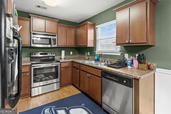 a kitchen with granite countertop stainless steel appliances and wooden cabinets