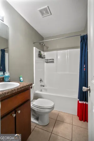 a bathroom with a granite countertop sink mirror vanity and toilet