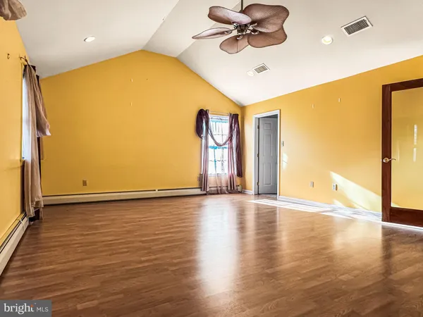 a view of an empty room and window with a ceiling fan