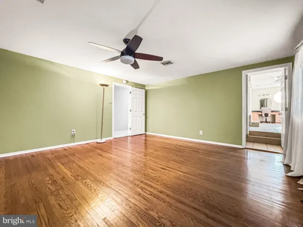 a view of a livingroom with wooden floor and a ceiling fan
