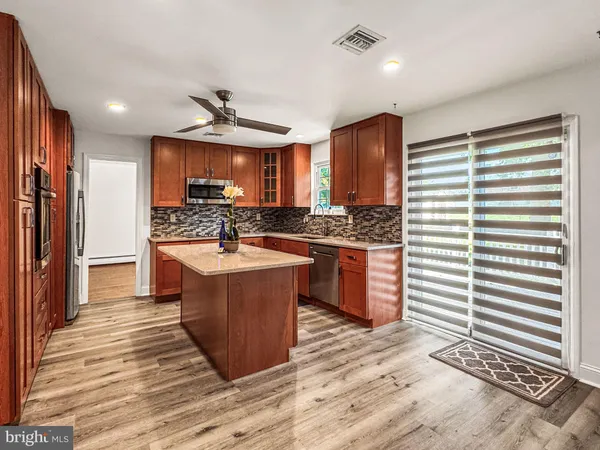 a kitchen with stainless steel appliances granite countertop a stove a sink and a refrigerator