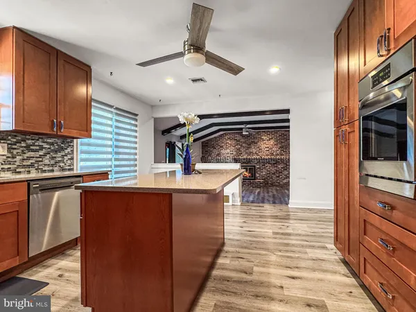 a kitchen with stainless steel appliances kitchen island granite countertop a sink and wooden cabinets