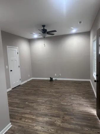 a view of a room with wooden floor and ceiling fan