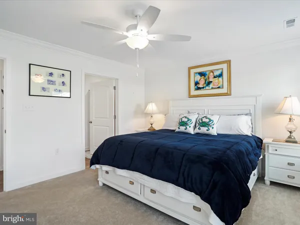 a bedroom with a bed and a lamp on dresser