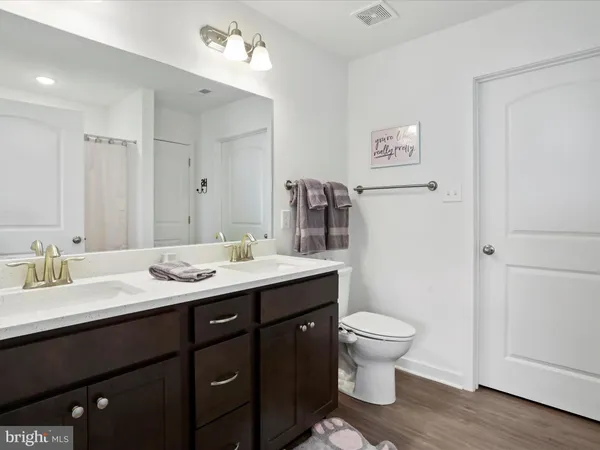 a bathroom with a granite countertop sink a toilet and a mirror