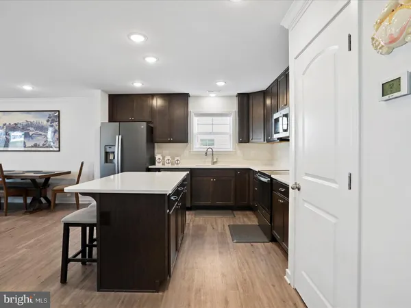a kitchen with a sink a counter top space and stainless steel appliances