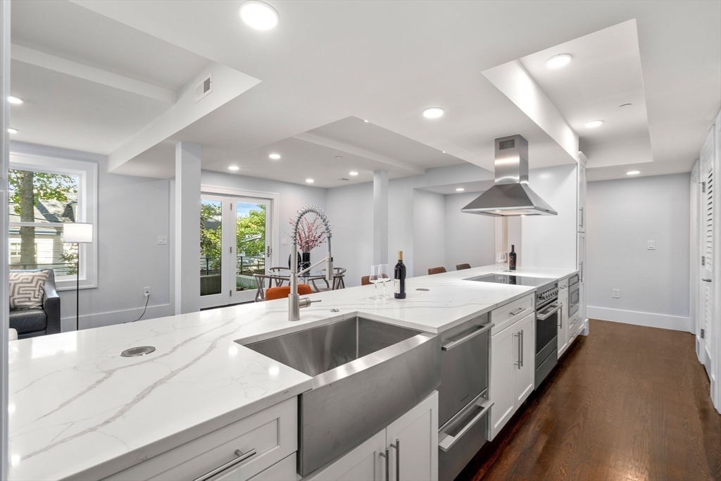 111 Winthrop Road, Unit 1 Brookline, MA 02445 - Photo 12 of 20 a large white kitchen with a large window and stainless steel appliances