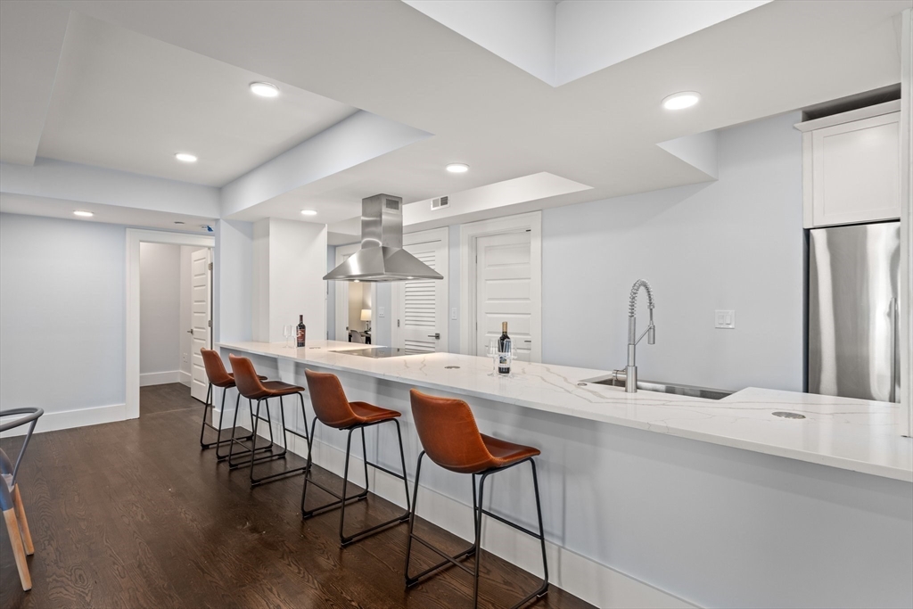 111 Winthrop Road, Unit 1 Brookline, MA 02445 - Photo 9 of 20 a kitchen with a dining table chairs sink and cabinets