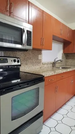 a kitchen with stainless steel appliances granite countertop a stove microwave and sink