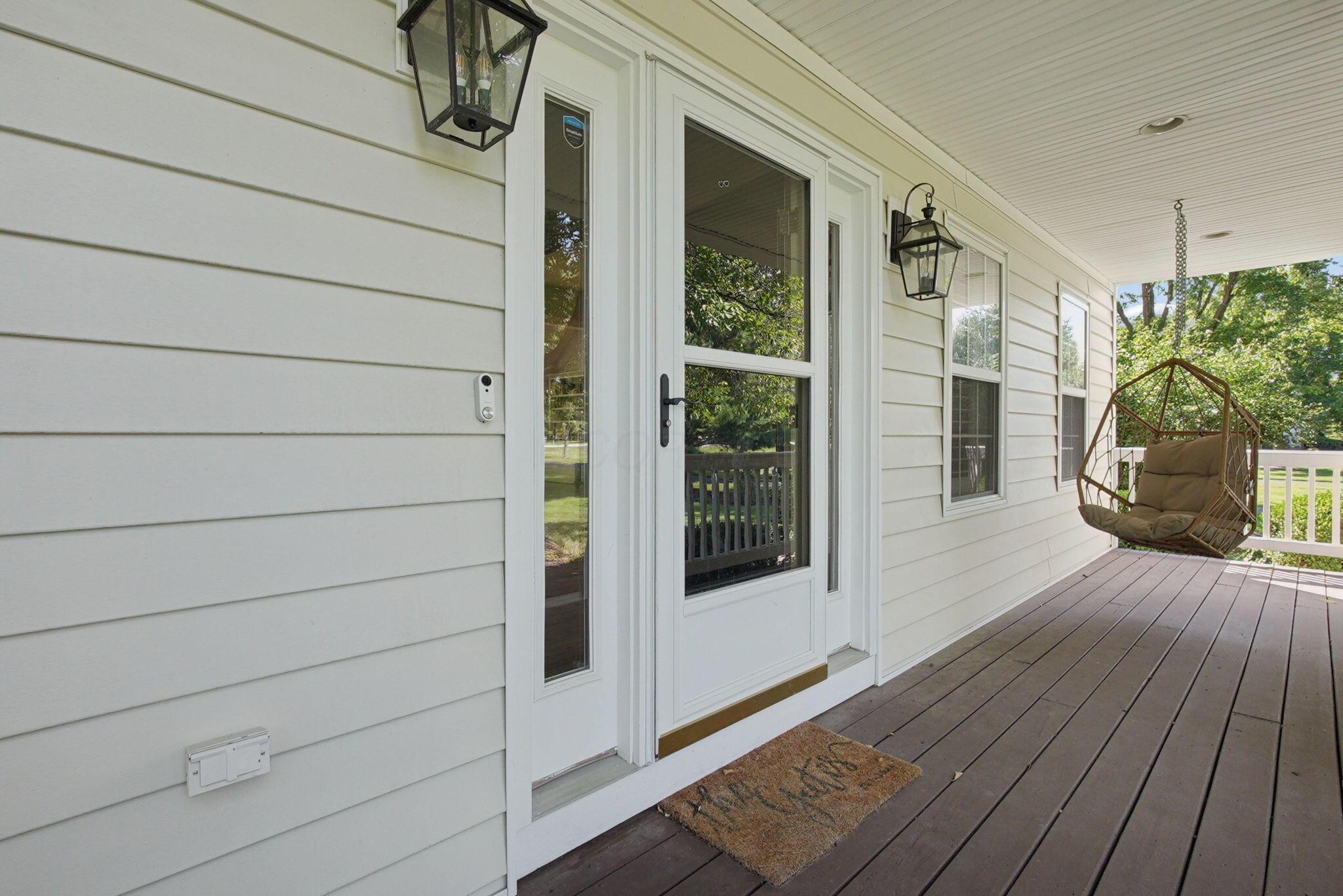 9435 Concord Road Powell, OH 43065 - Photo 6 of 77 Covered porch with wood-finish decking, horizontal siding, and multiple light fixtures
