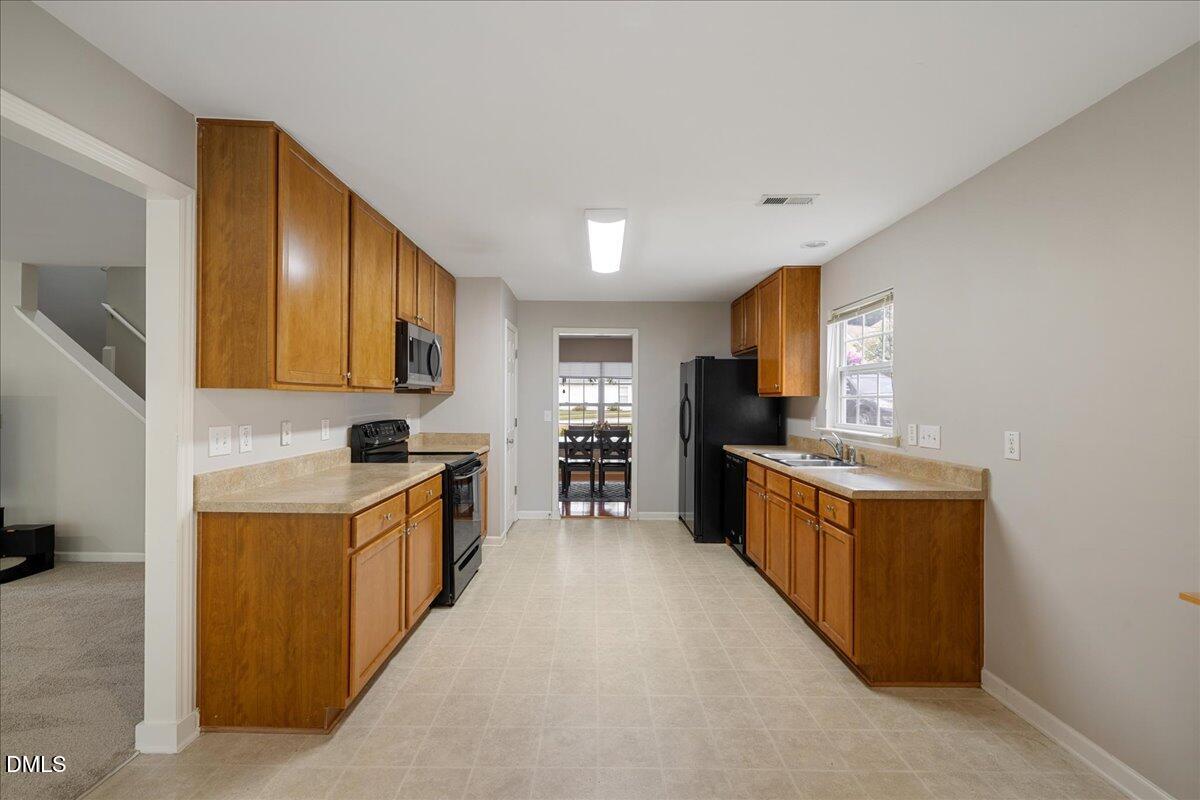 505 Pyracantha Drive Holly Springs, NC 27540 - Photo 14 of 41 a large kitchen with stainless steel appliances granite countertop a stove and a sink
