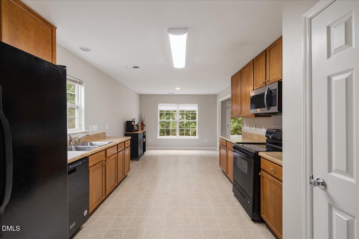 505 Pyracantha Drive Holly Springs, NC 27540 - Photo 15 of 41 a large kitchen with stainless steel appliances granite countertop a stove refrigerator and a sink