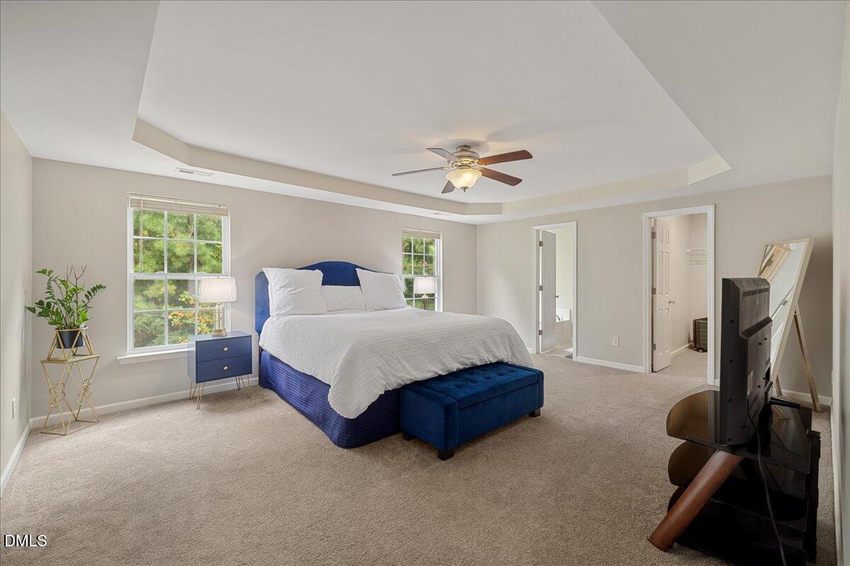505 Pyracantha Drive Holly Springs, NC 27540 - Photo 21 of 41 a spacious bedroom with a bed and a chandelier