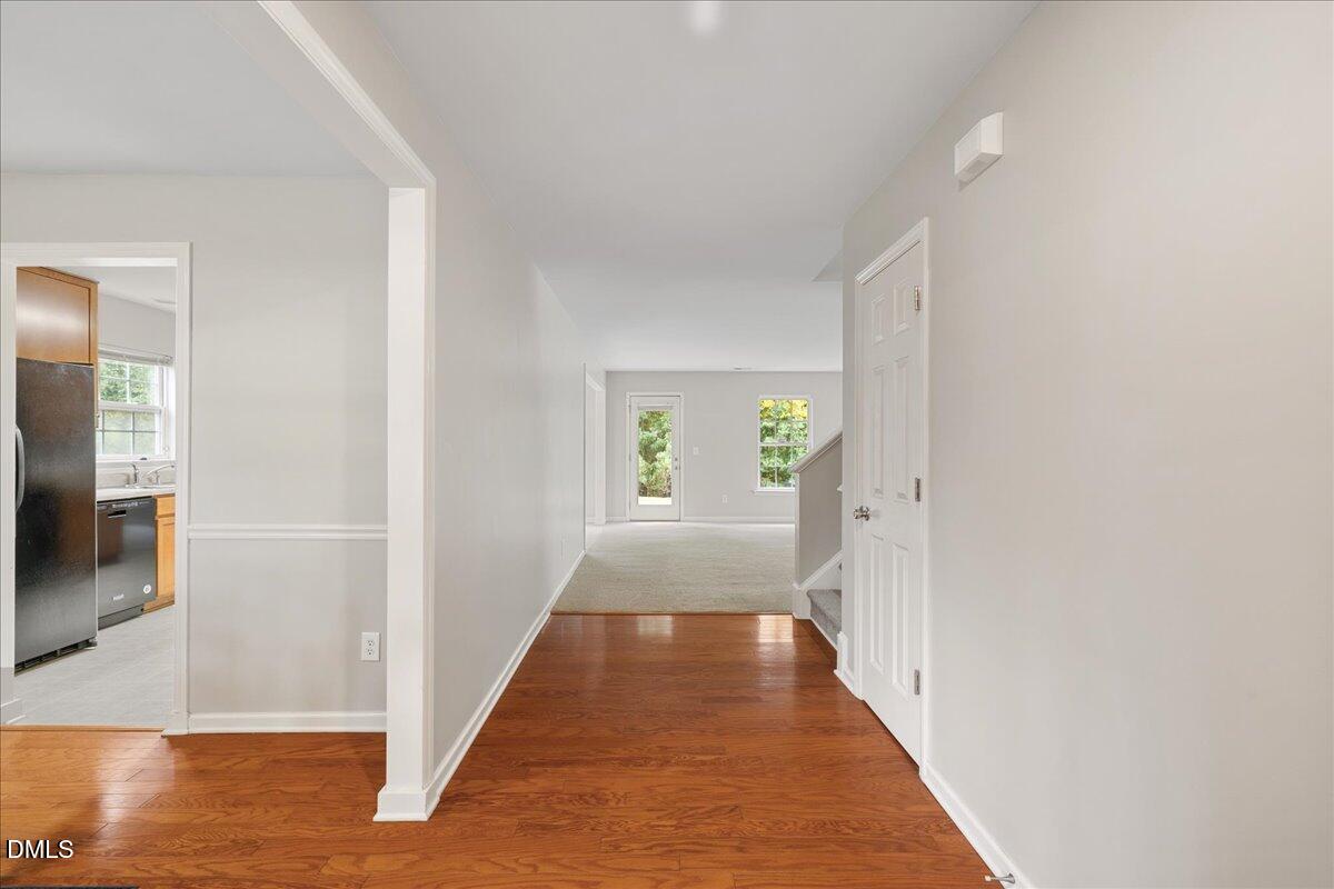 505 Pyracantha Drive Holly Springs, NC 27540 - Photo 5 of 41 a view of a hallway with wooden floor and a living room