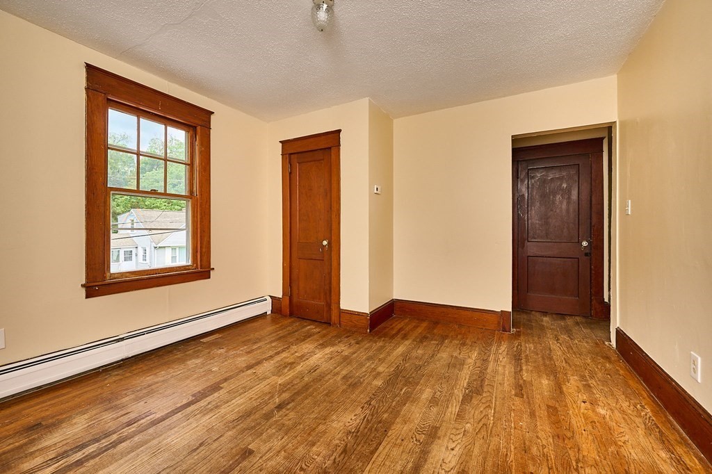 19 Powell Street Northampton, MA 01062 - Photo 17 of 40 an empty room with wooden floor and windows