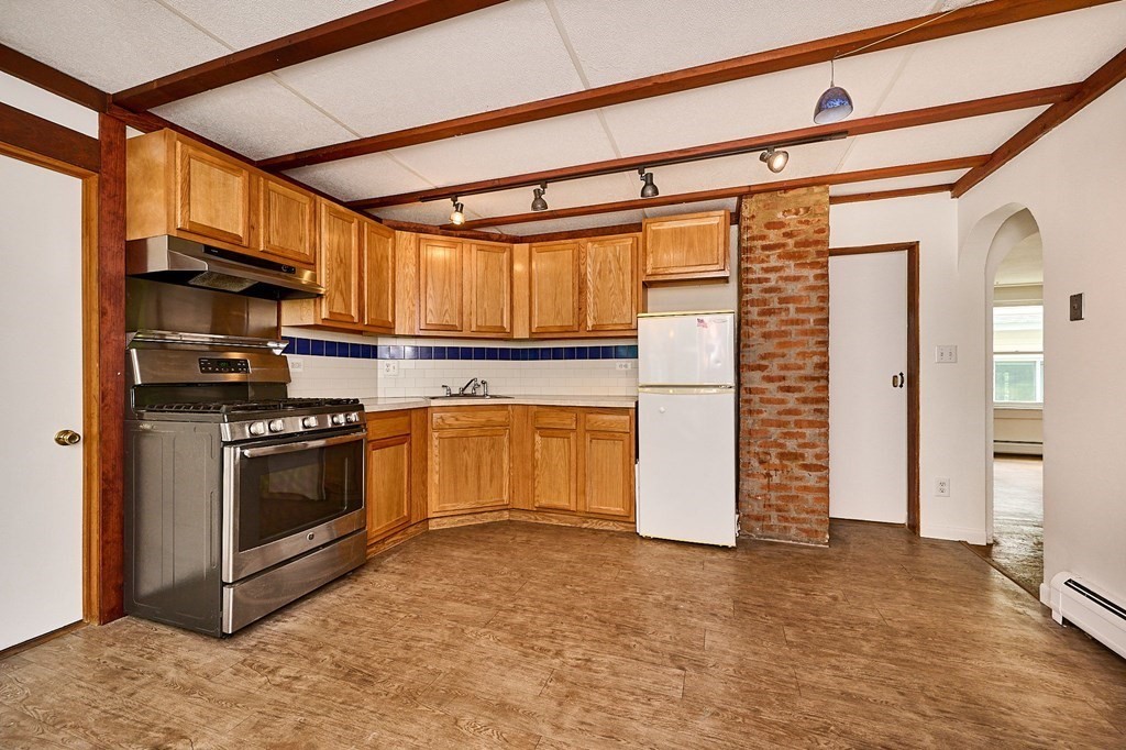 19 Powell Street Northampton, MA 01062 - Photo 7 of 40 a kitchen with granite countertop a refrigerator and a stove top oven