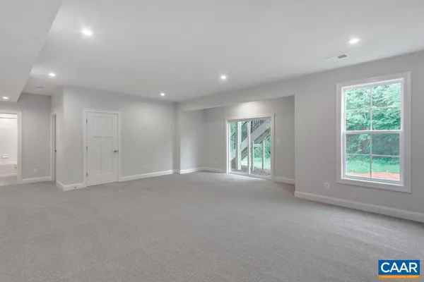 a view of a backyard with plants and large trees