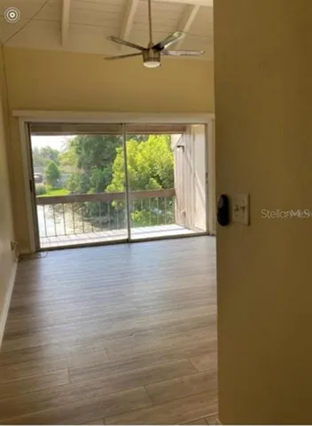 a view of a room with wooden floor and a window