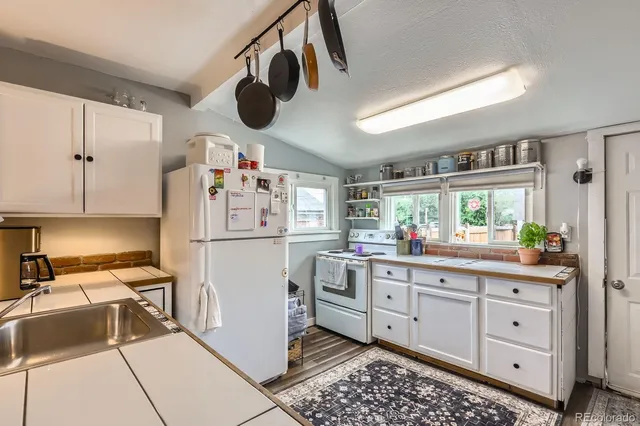 a kitchen with a refrigerator and white cabinets