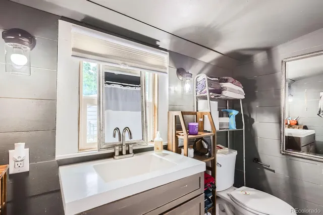 a bathroom with a sink vanity mirror and toilet