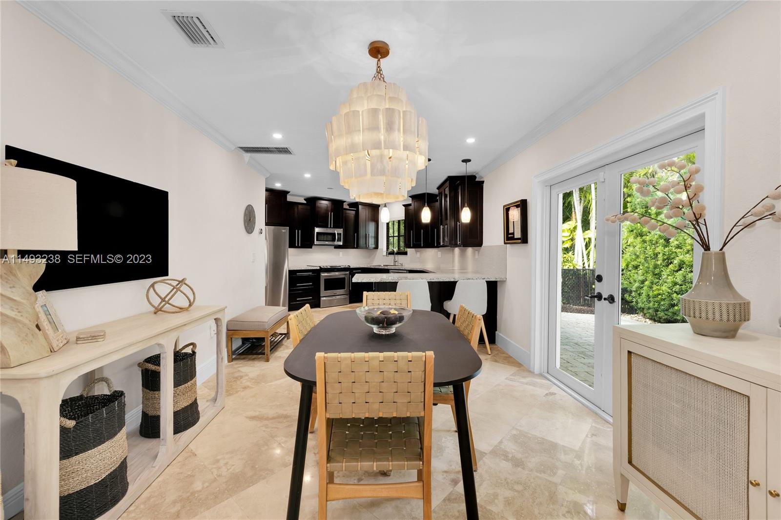 605 Blue Road Coral Gables, FL 33146 - Photo 12 of 34 a view of a dining room with furniture a kitchen and chandelier