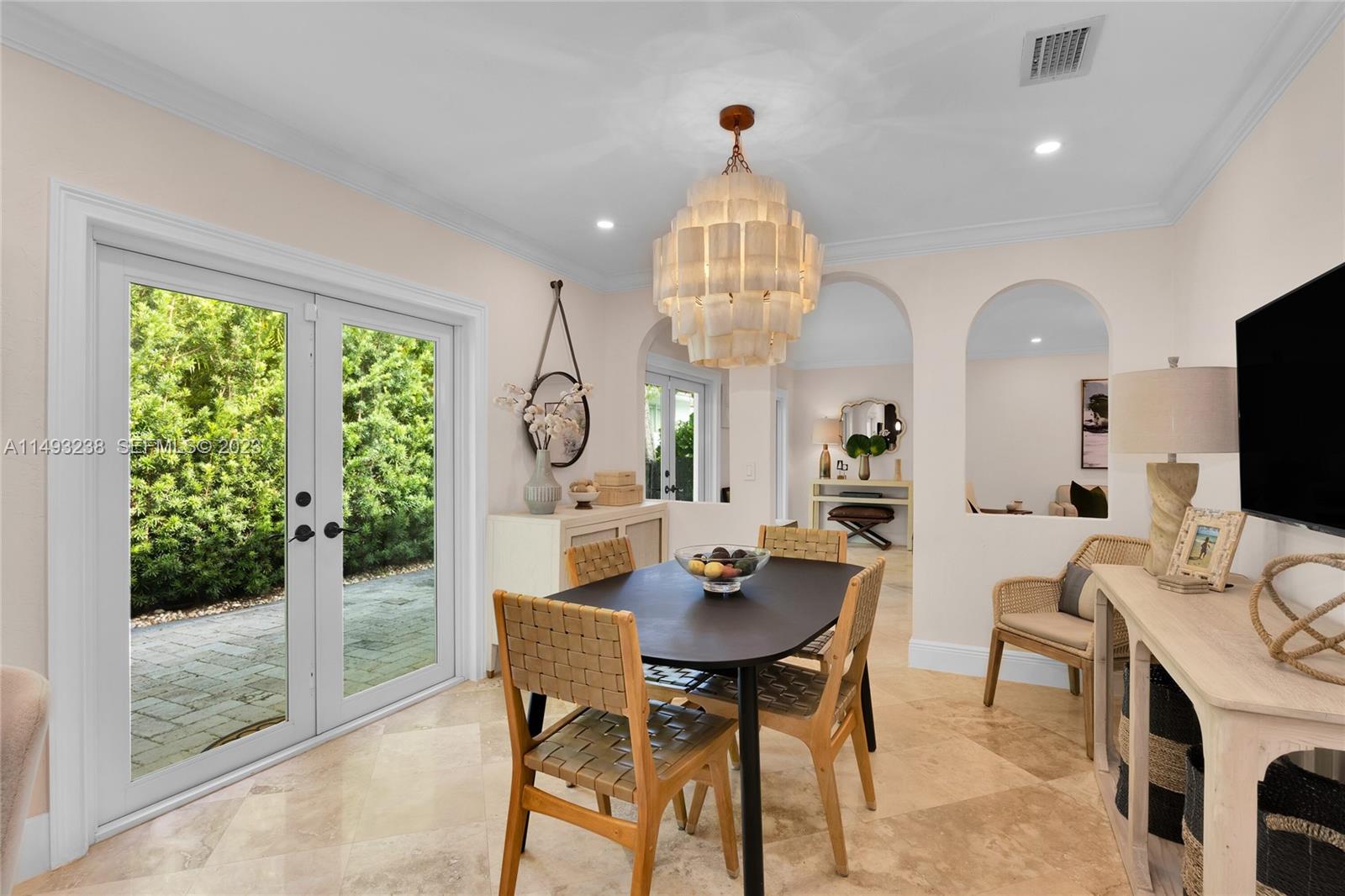 605 Blue Road Coral Gables, FL 33146 - Photo 13 of 34 a view of a dining room with furniture a chandelier and wooden floor