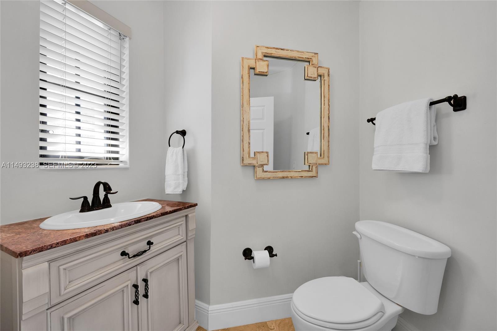 605 Blue Road Coral Gables, FL 33146 - Photo 25 of 34 a bathroom with a granite countertop sink toilet and mirror