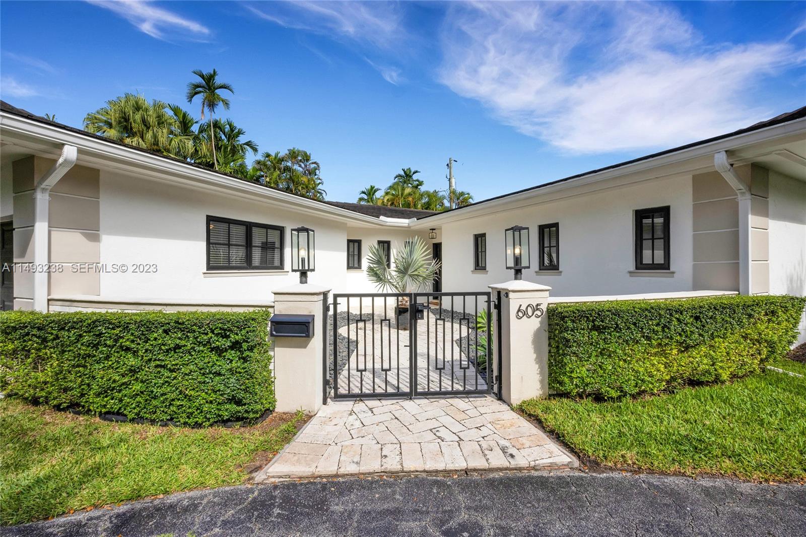 605 Blue Road Coral Gables, FL 33146 - Photo 5 of 34 a front view of a house with a garden
