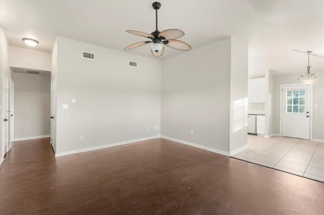 a view of a room with a stylish ceiling fan and entryway
