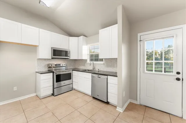 a kitchen with granite countertop white cabinets and appliances