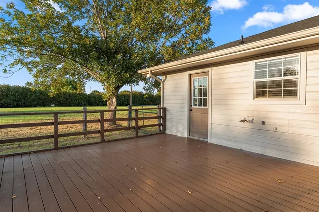 a view of a deck with wooden floor and fence