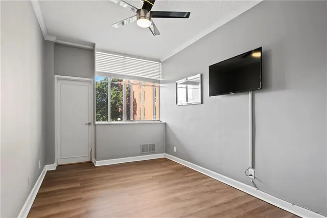 an empty room with wooden floor and windows