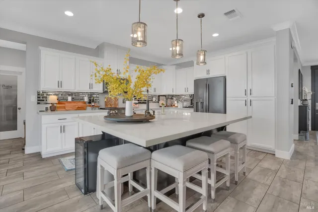a kitchen with a dining table chairs stainless steel appliances and cabinets