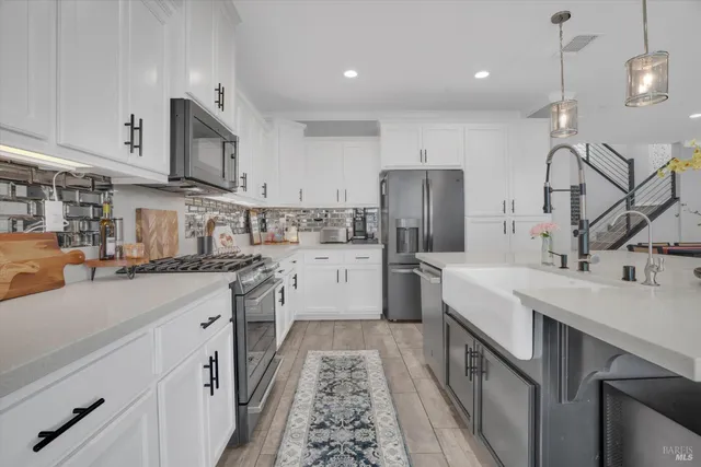 a kitchen with stainless steel appliances granite countertop a sink a stove and a refrigerator